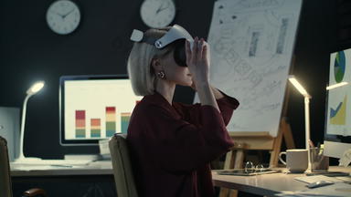 现代业务女人穿虚拟现实眼镜晚上办公室